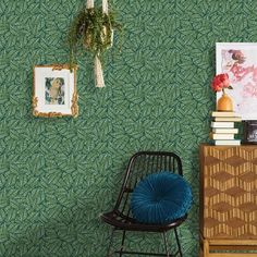 a room with green wallpaper and blue chair