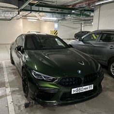 two cars parked in a parking garage next to each other on the floor and one is green