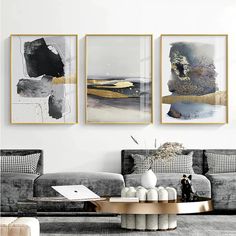 three abstract paintings hang on the wall above a coffee table in a modern living room