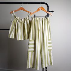 two green and white striped pants hanging on a rack