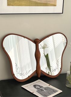 a butterfly shaped mirror sitting on top of a table