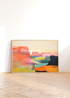 an abstract painting is displayed on the wall next to a wooden floor in front of a white wall