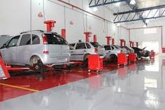 several cars are parked in a garage with red and yellow barriers on the floor next to them