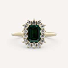 an emerald and diamond ring on a white background