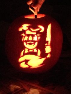 a carved pumpkin with an image of a man holding a knife in it's mouth