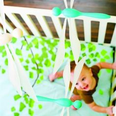 a baby in a crib with green and white decorations