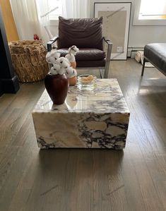 a marble coffee table sitting on top of a hard wood floor