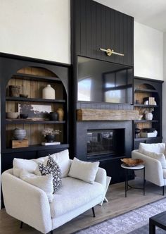 a living room filled with furniture and a fire place in the middle of it's wall