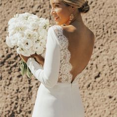 a woman in a white dress holding a bouquet of flowers