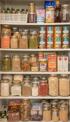 an organized pantry filled with lots of different types of food and spices, including cereals