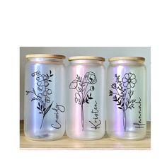 three glass jars with flowers painted on them