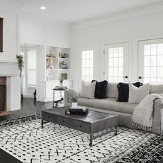 a living room filled with furniture and a fire place in front of a white fireplace