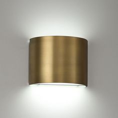 a wall mounted light with a round shade on it's side and the lights are off