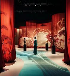 a woman is standing in the middle of a room with red drapes on it