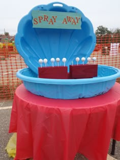 there is a blue tray with pins in it on top of a red table cloth