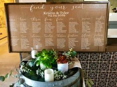 a table with flowers and candles on top of it next to a sign that says find your seat