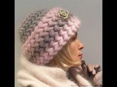 a woman wearing a knitted hat with a button on it's side and a scarf around her neck