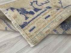 two blue and beige rugs laying on top of a wooden floor next to each other