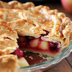 a pie that is sitting on top of a glass plate with some fruit in it