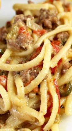 a white plate topped with pasta and meat