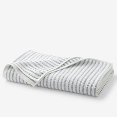 a white and blue striped blanket folded on top of each other