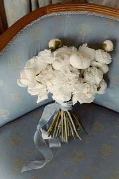 a bouquet of white flowers sitting on top of a blue chair