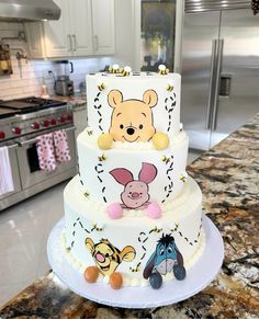 a three tiered winnie the pooh cake on top of a counter in a kitchen