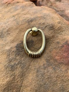 a metal ring sitting on top of a rock