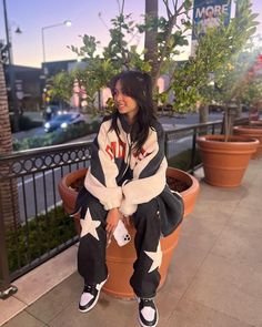 a woman sitting on top of a potted plant