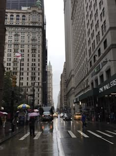 people with umbrellas are walking down the street on a rainy day in new york city