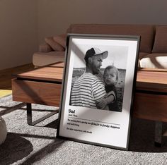 a photo frame sitting on the floor next to a bench with a man holding a baby