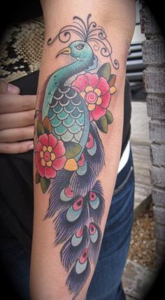 a peacock with flowers on it's arm and the colors are blue, green, red