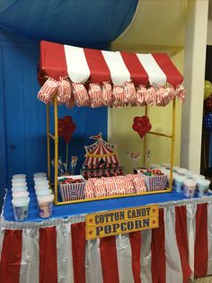 a carnival themed dessert table with red and white striped umbrellas on it's sides