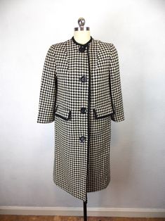 "Vintage 1950's 1960's woman's wool coat in a houndstooth pattern. Fully lined. Pockets. Three quarter length sleeves. Very good vintage condition. Length 36\" Shoulders 14\" Sleeves 3/4 length Bust 34\" Waist 36\" Hips 38\"/40\" Please note that vintage clothing and contemporary sizes can vary greatly. We take measurements of listed garments by laying the garment flat and then doubling the measurement. When considering whether a garment would fit, we suggest taking a similar garment from your own wardrobe and measure it lying flat as we do. Then compare the measurements." Vintage Tweed Outerwear For Office, Fitted Vintage Outerwear With Houndstooth Pattern, Vintage Plaid Outerwear For Office, Vintage Houndstooth Outerwear, Vintage Houndstooth Outerwear For Winter, Vintage Wool Houndstooth Outerwear, Wool Houndstooth Vintage Outerwear, Tennis Sweater, Houndstooth Coat