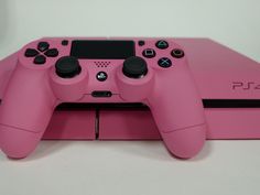 a close up of a pink playstation 4 game controller