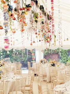 an image of a wedding venue with flowers hanging from the ceiling and tables set up