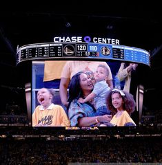 a large screen at a basketball game with people on it