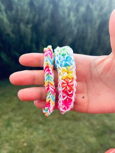 two rainbow loom bands are held in someone's hand