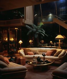 a living room filled with lots of furniture next to a stair case in front of a window