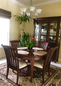 a dinning room table with chairs and a potted plant on top of it