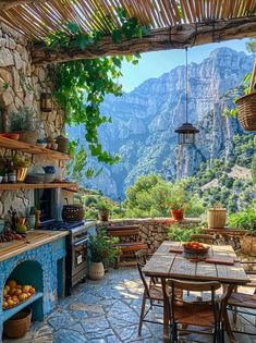 an outdoor dining area with stone walls and mountains in the backgroung, surrounded by greenery