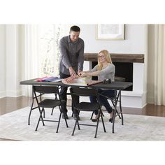 two people standing around a table with chairs