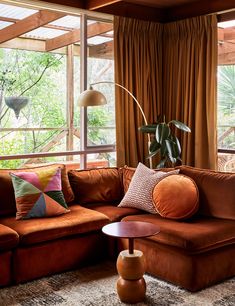 a living room filled with furniture and large windows