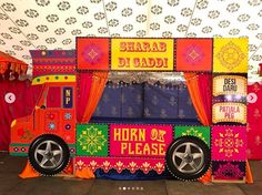 an elaborately decorated food truck sits in the middle of a room with red drapes