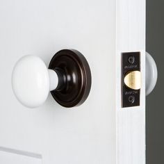 an open door with a white knob and black handle