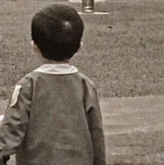 a young boy standing on top of a baseball field