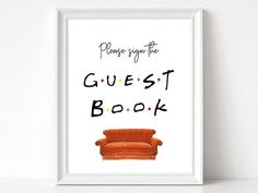 a poster with the words guest book in black and white, on top of an orange couch