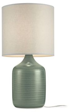 a green table lamp with a white shade on the base and a cord attached to it