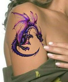 a woman's arm with a purple dragon tattoo on the side of her shoulder