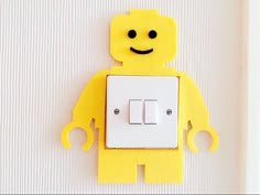 a yellow robot light switch cover on a white wall